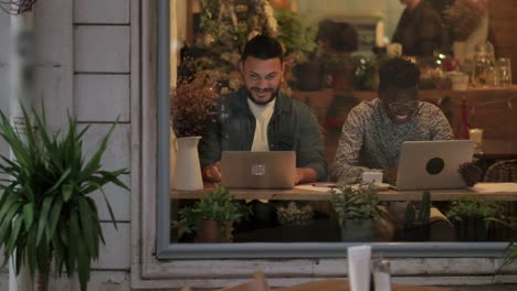 Trabajadores-Independientes-Felices-Usando-Computadoras-Portátiles-En-La-Cafetería